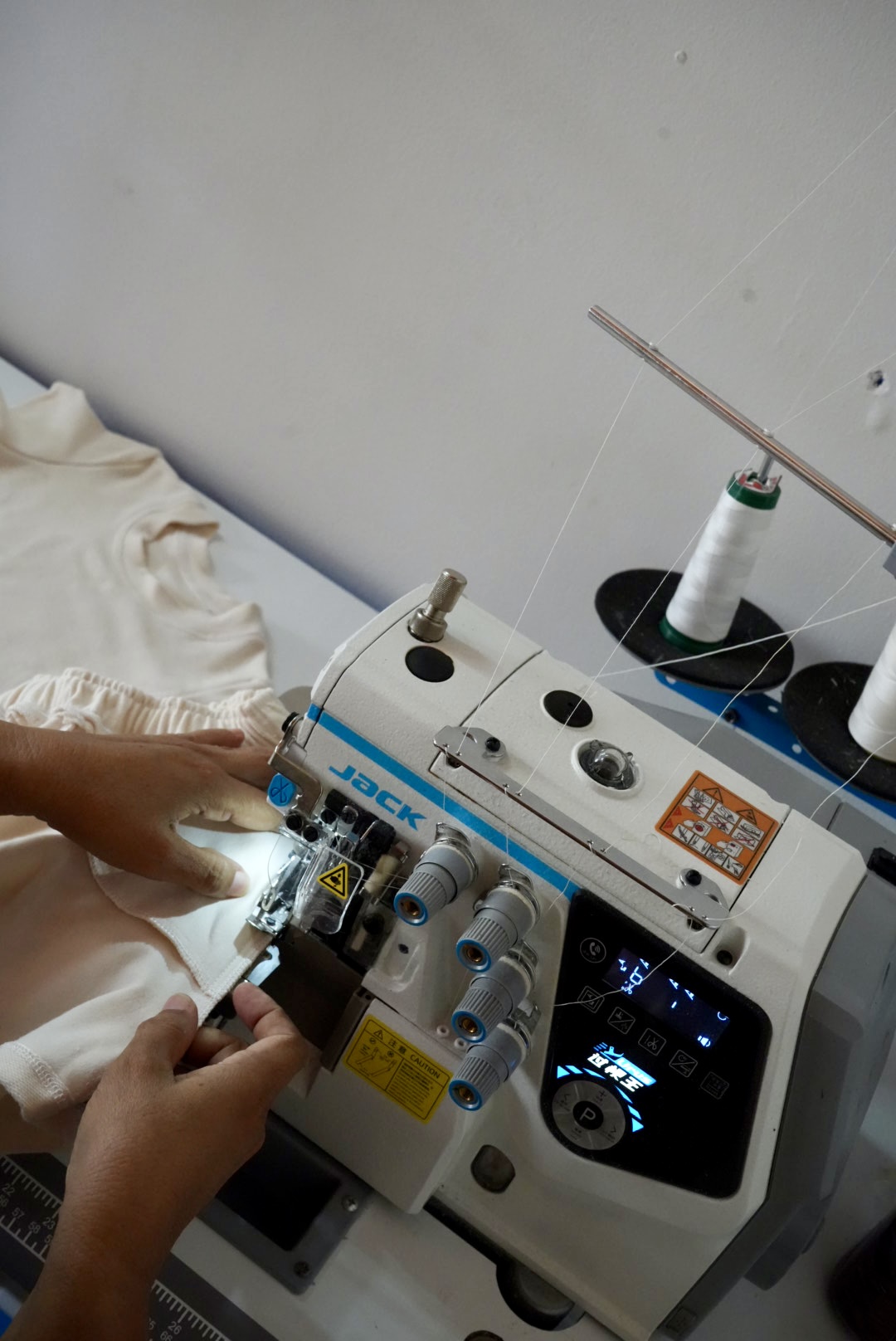 Fileteado en máquina overlock industrial, confección en proceso